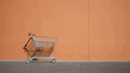 Zu sehen ist ein Einkaufswagen vor einer orangefarbenen Wand. © Imago / Westend61 Foto: Westend61
