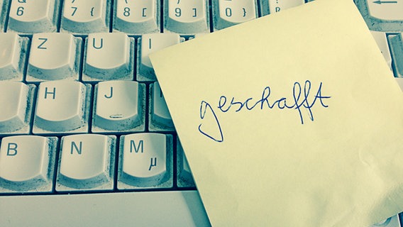 Auf einem Post-it steht "geschafft" geschrieben. © NDR 