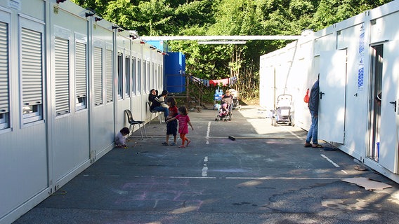 Zwischen zwei Containerreihen spielen Kinder. © n-joy Foto: Antje Barthold