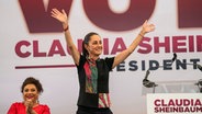 Claudia Shienbaum, Kandidatin bei der Präsidentschaftswahl 2024 in Mexiko, reißt beide Arme hoch © dpa Foto: Marco Ugarte