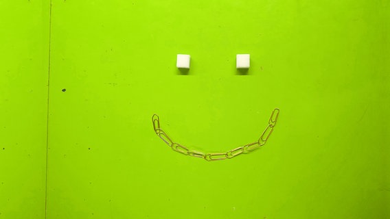 Smiley aus Büroklammern und Zuckerstücken © N-JOY 